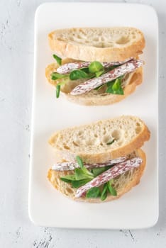 Sandwich with mini fuets and corn salad on the white background