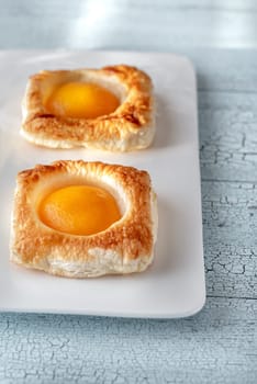 Puff pastry with canned peaches on the wooden table