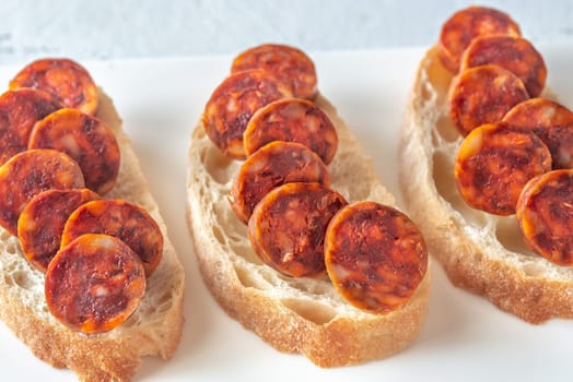 Sandwich with spanish chorizo on the white plate