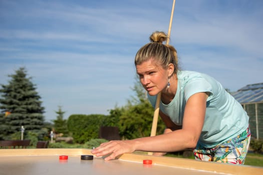 Women playing Novuss in outdoors. Novuss is a national sport in Latvia similar to pocket billiards or pool.