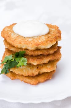 fried potato pancakes with parsley on white plate