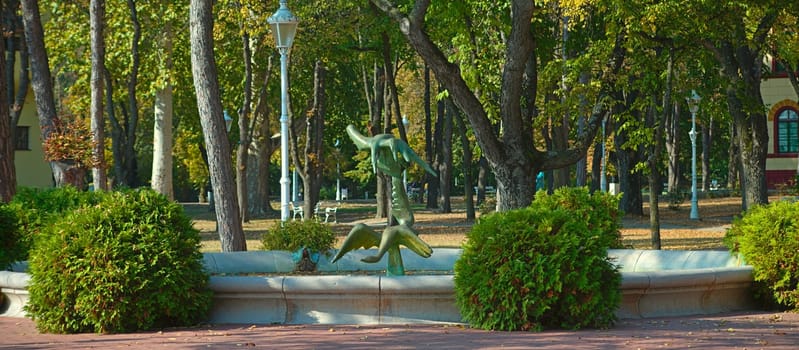 Public park with fountain and statue in the middle