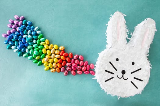 Cheerful Piñata with chocolate easter eggs in rainbow colors