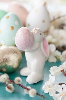 Cute bunny holding an easter eggs and spring blossoms