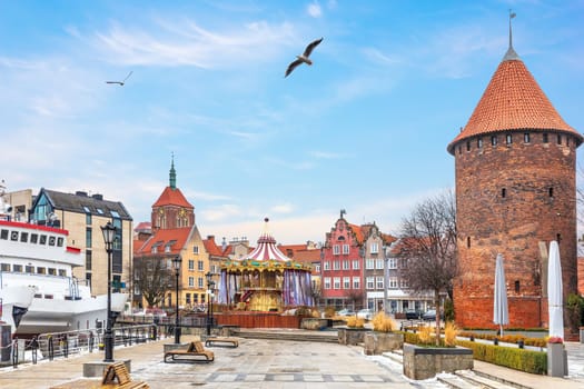 Swan Tower, the Dome of the Church and the carrousel on the bank of the Motlawa in Gdansk, Poland.