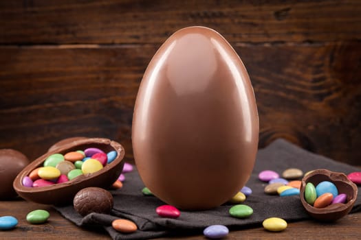 Delicious chocolate Easter holiday egg on rustic background