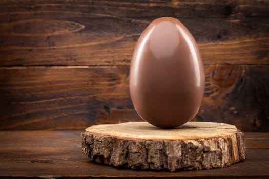 Delicious chocolate Easter holiday egg on rustic background
