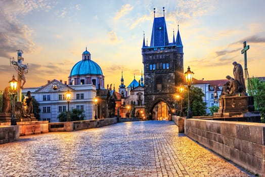 Charles Bridge and Old Town Bridge Tower in Prague at sunrise.