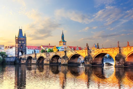 Charles bridge over Vltava river in Prague at sunrise.