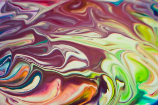 Colorful liquid paints mixed together creating modern abstract