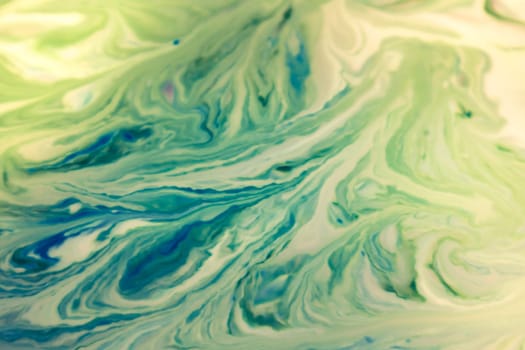 Colorful liquid paints mixed together creating modern abstract