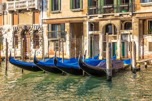 Venice palace with gondolas moored in Grand Canal, Italy.