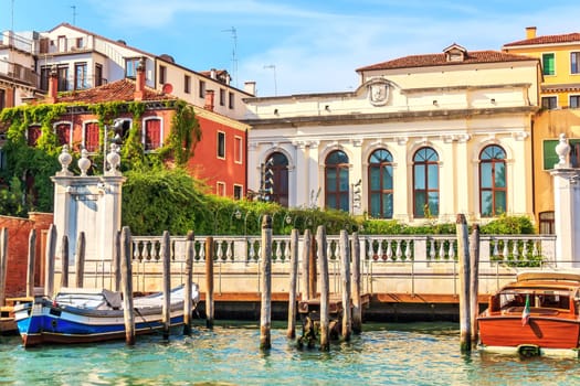 Channel of Venice with luxurious houses and boats moored, Italy.