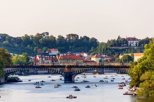 Paddleboats in the Vltava river under Manes Bridge and Charles bridge, Prague, summer view.