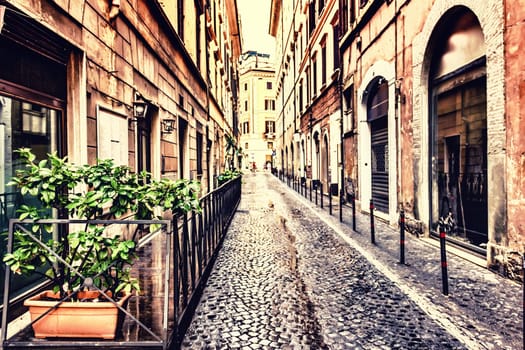 Narrow Italian street with a cozy cafe terrace in a fashionable part of Rome