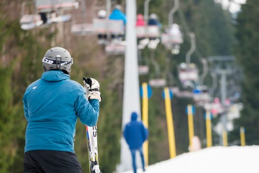 Szklarska Poreba, Poland - February 2019 : Skier wearing blue ski jacket resting on his ski equipment, Szrenica mountain, Karkonosze mountains
