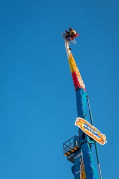 London, England - November 2018 : Riders on the scary ride high in the air on a sunny day in an amusement park