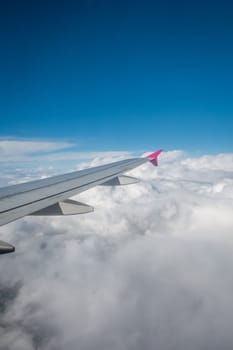 Luton, England - September 2018 : Window view of the wing of an airplane flying above the clouds