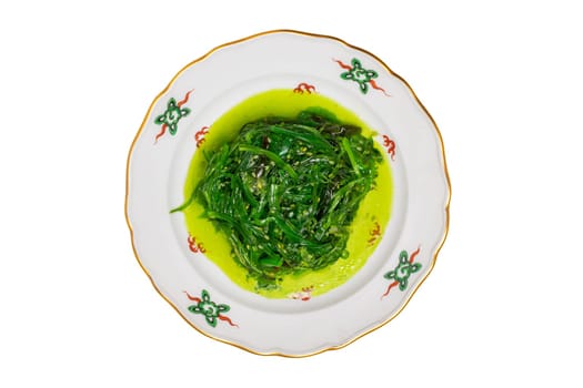 Japanese food. Close-up of Chuka or seaweed salad with sesame seeds on a colorful plate isolated on a white background. Seafood background. Health concept.
