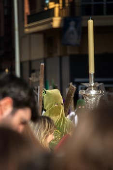 SEVILLE, SPAIN - MARCH 25: Man with green hood in a Holy Week procession in Seville, Spain on March 25, 2018