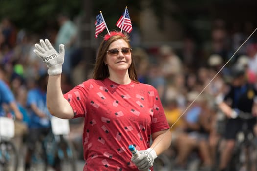 Indianapolis, Indiana, USA - May 26, 2018, Woman with headwear with two american flags holds down a balloon at the Indy 500 Parade