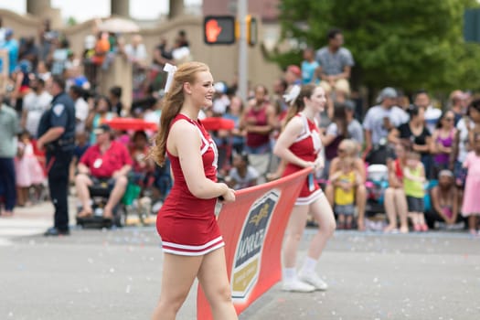 Indianapolis, Indiana, USA - May 26, 2018,  A cheerleader from the Indiana University smiles walking down the street at the Indy 500 Parade
