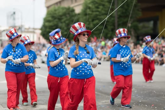 Indianapolis, Indiana, USA - May 26, 2018,  Men and women wearing clothing with the colors of the american flag holding a balloon at the Indy 500 Parade