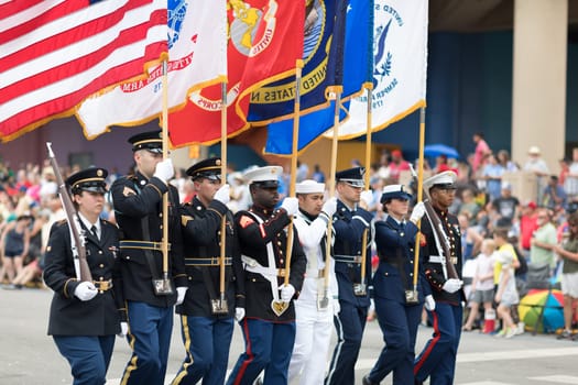 Indianapolis, Indiana, USA - May 26, 2018,  Members of the US Military carrying the American flag marching down the street during the Indy 500 Parade
