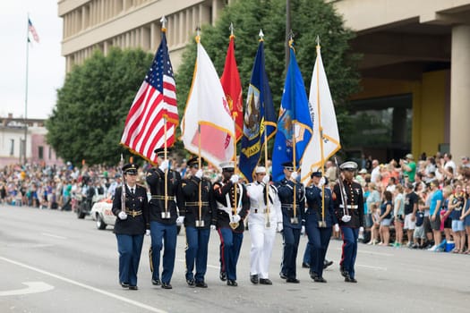 Indianapolis, Indiana, USA - May 26, 2018,  Members of the US Military carrying the American flag marching down the street during the Indy 500 Parade