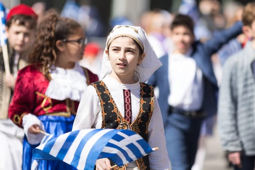 Chicago, Illinois, USA - April 29, 2018  Greek Children wearing traditional clothing and waving greek flags during the Greek Independence  Day Parade