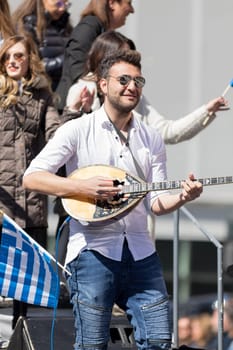 Chicago, Illinois, USA - April 29, 2018 Greek man playing Baglamas during the  Greek Independence  Day Parade
