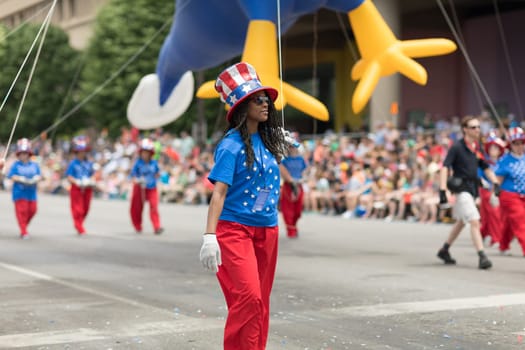 Indianapolis, Indiana, USA - May 26, 2018,  Men and women wearing clothing with the colors of the american flag holding a balloon at the Indy 500 Parade