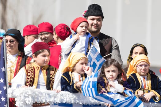 Chicago, Illinois, USA - April 29, 2018  Children wearing traditional clothing waving the greek flag during the Greek Independence  Day Parade