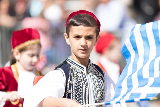 Chicago, Illinois, USA - April 29, 2018 Members of a greek school wearing traditional clothing and waving greek flags during the Greek Independence  Day Parade