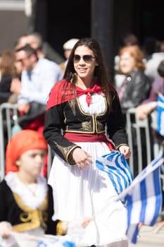 Chicago, Illinois, USA - April 29, 2018  Greek woman wearing traditional clothing waving the greek flag at the Greek Independence  Day Parade