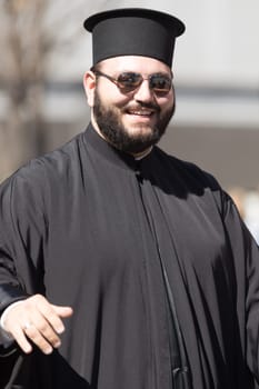 Chicago, Illinois, USA - April 29, 2018 An orthodox priest smiles at the Greek Independence  Day Parade