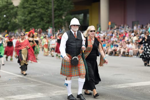 Indianapolis, Indiana, USA - May 26, 2018,  People from different countries with traditional clothing and carrying national flags at the Indy 500 Parade