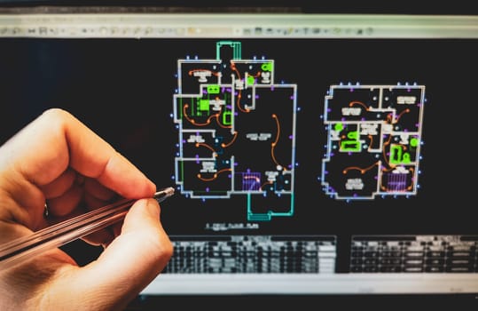 cad software drawing on the computer screen with hand holding pen .