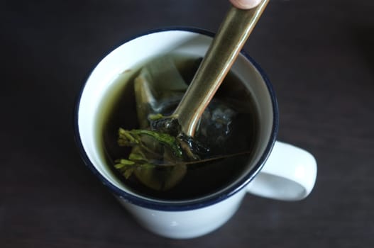 ea with Green and dired Stevia leaves in white glass