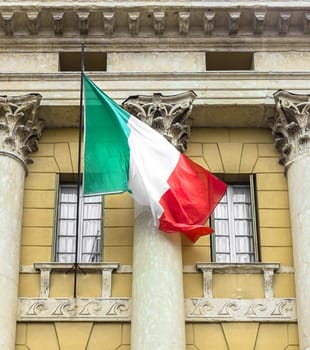 Italian flag on facade of an old building. Close-up.
