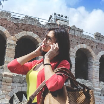 Portrait of a young tourist talking on phone. Vintage colors.