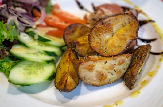 Roasted potatoes with rosemary, served with summer salad as addition to the grilled bacon wrapped chicken