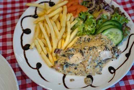 Grilled chicken breast with honey glazed mustard sauce meal served with summer salad and chips