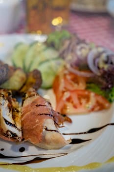 Grilled bacon and ham wrapped chicken breast,  served with summer salad and roast potatoes