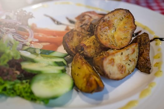 Roasted potatoes with rosemary, served with summer salad as addition to the grilled bacon wrapped chicken