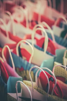 Row of colourful paper gift bags for sale on market