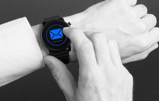 Black smartwatch isolated on a black background, new message