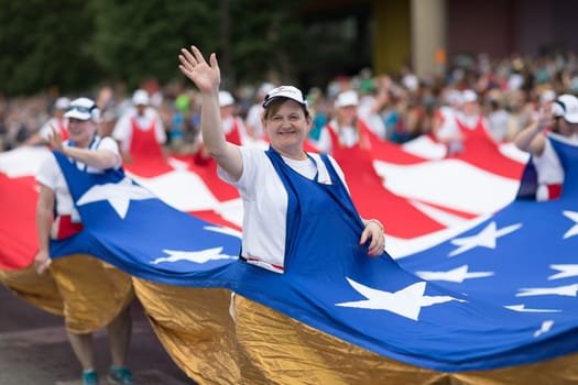 Indianapolis, Indiana, USA - May 26, 2018,  People carrying a giant American flag through the streets at the Indy 500 Parade