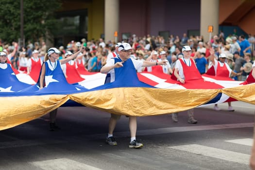 Indianapolis, Indiana, USA - May 26, 2018,  People carrying a giant American flag through the streets at the Indy 500 Parade