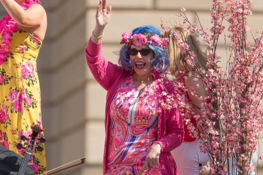 Washington, D.C., USA - April 14, 2018 A woman wearing a colorful dress, a flowers crown with blue hair in the 2018 National Cherry Blossom Parade